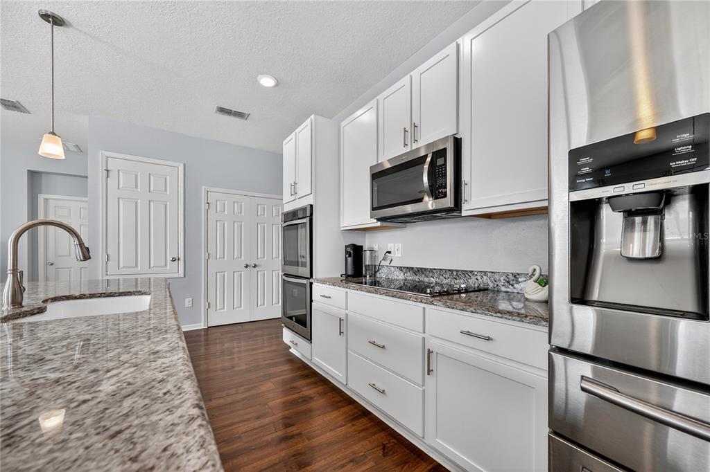 4368 Moon Shadow Loop Mulberry, FL 33860 - Photo 7 of 39 a kitchen with granite countertop a refrigerator stove and microwave