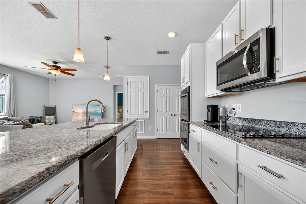4368 Moon Shadow Loop Mulberry, FL 33860 - Photo 8 of 39 a large kitchen with granite countertop a sink and stove top oven