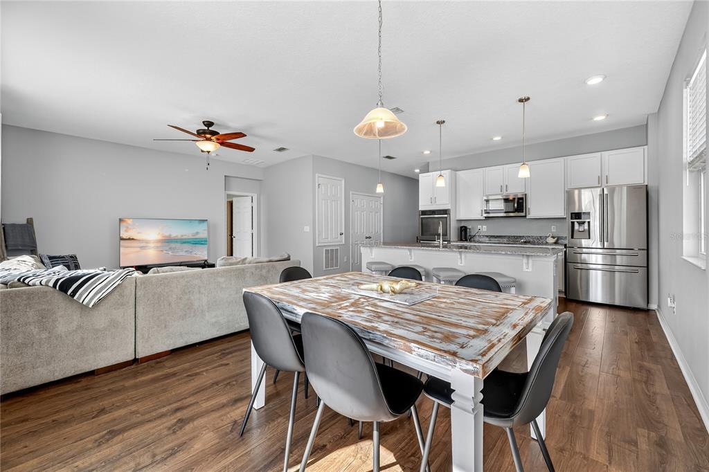 4368 Moon Shadow Loop Mulberry, FL 33860 - Photo 10 of 39 a kitchen with granite countertop a table chairs stainless steel appliances and wooden floor