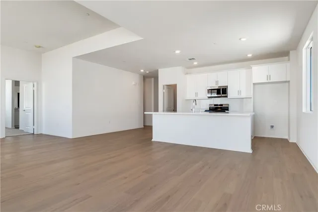 a view of kitchen with wooden floor and electronic appliances
