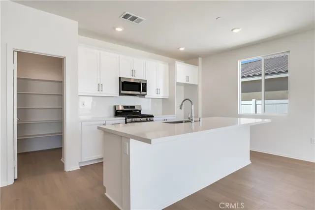 a kitchen with stainless steel appliances a sink stove and refrigerator