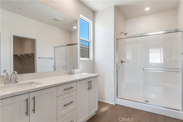 a bathroom with a double vanity sink mirror and shower
