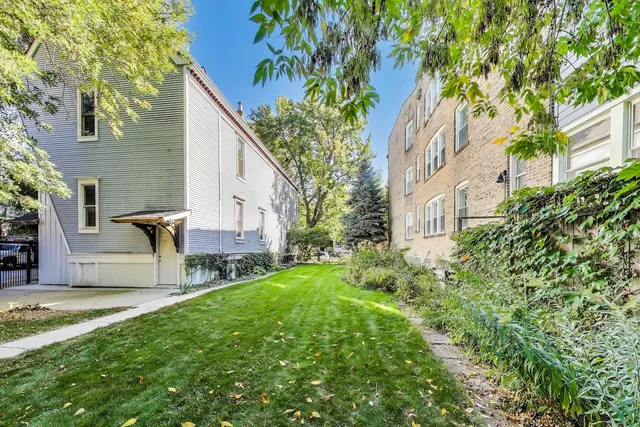 a view of backyard of house with outdoor seating and green space
