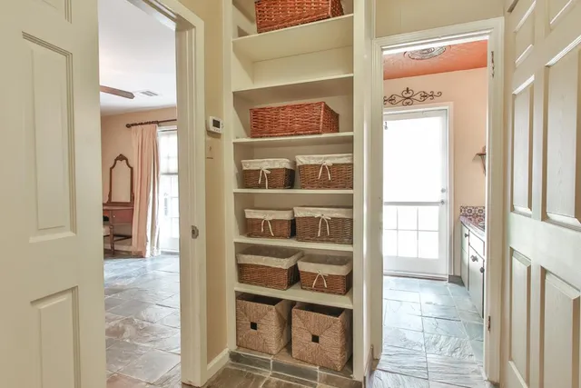 a view of a hallway with a cabinet and a window
