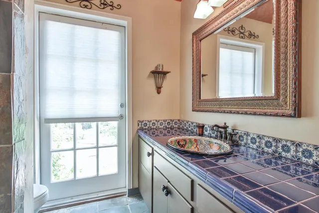 a bathroom with a sink a mirror and a window