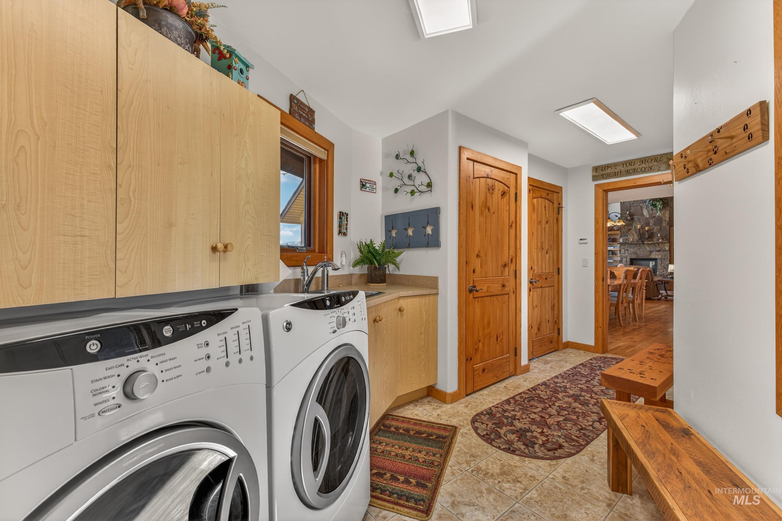 8 Bitterroot Court McCall, ID 83638 - Photo 26 of 50 Laundry room featuring independent washer and dryer, a stone fireplace, and cabinet space