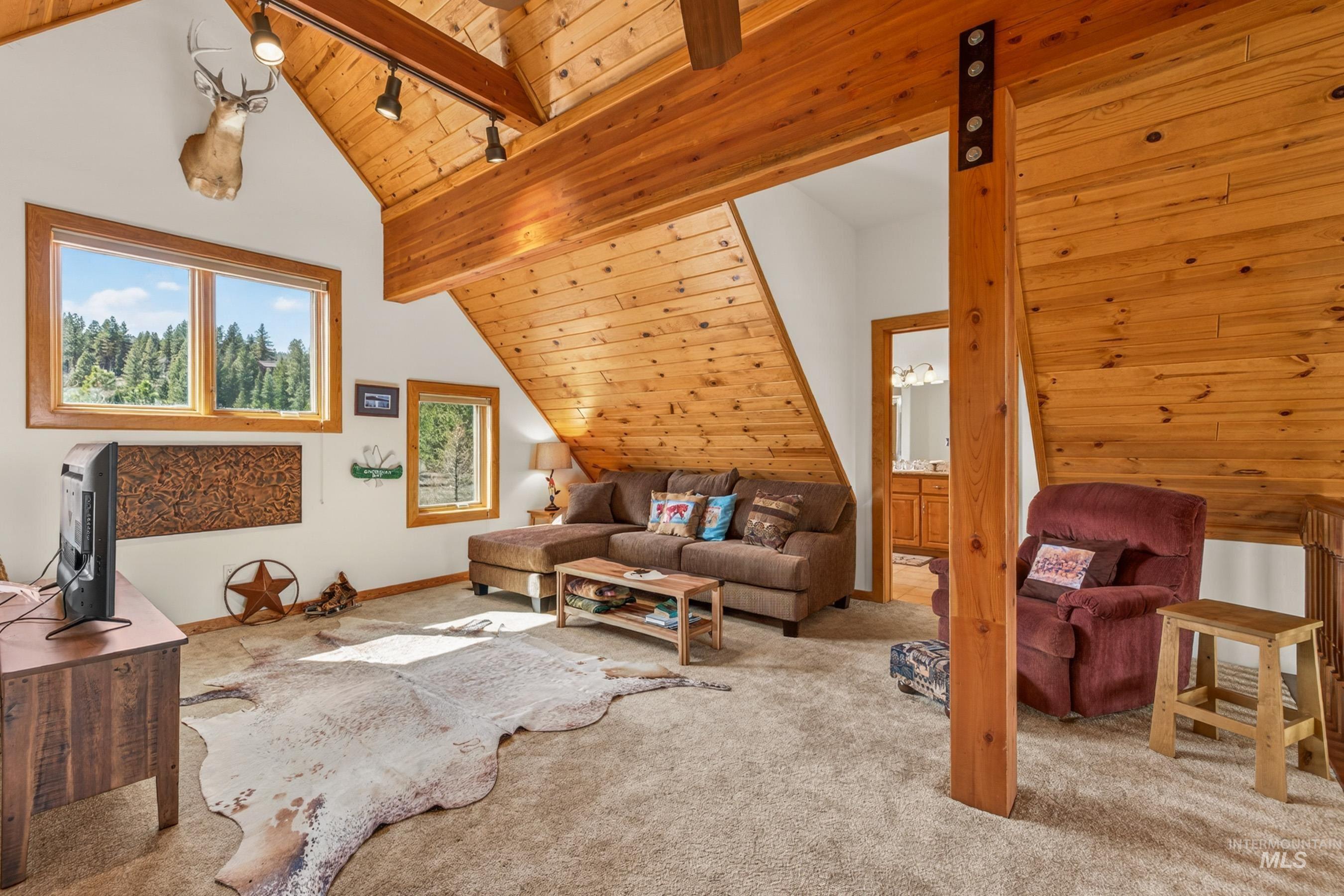8 Bitterroot Court McCall, ID 83638 - Photo 28 of 50 Carpeted living area with rail lighting and a high wood beamed ceiling