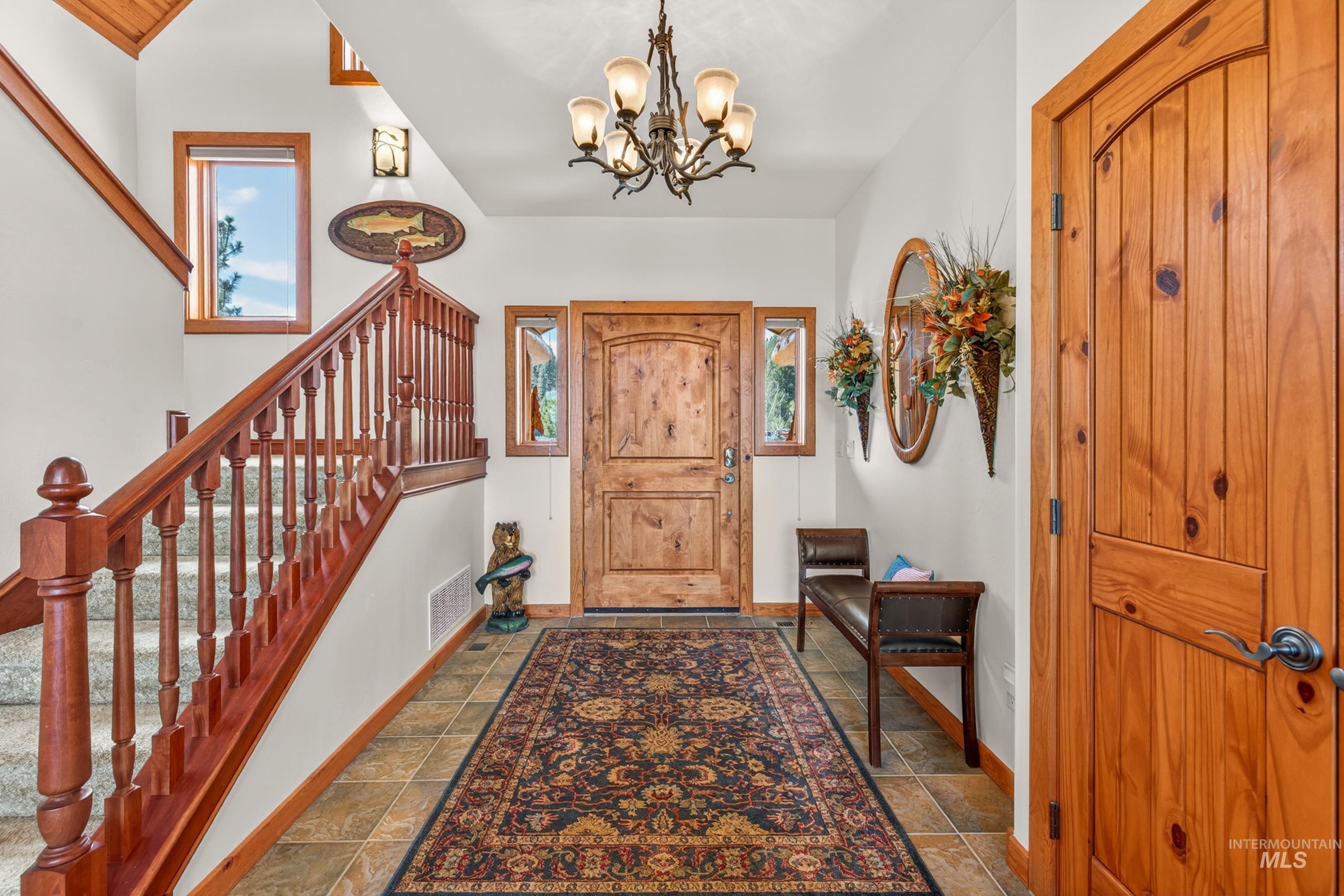 8 Bitterroot Court McCall, ID 83638 - Photo 4 of 50 Foyer entrance with stone tile floors and suspended lighting
