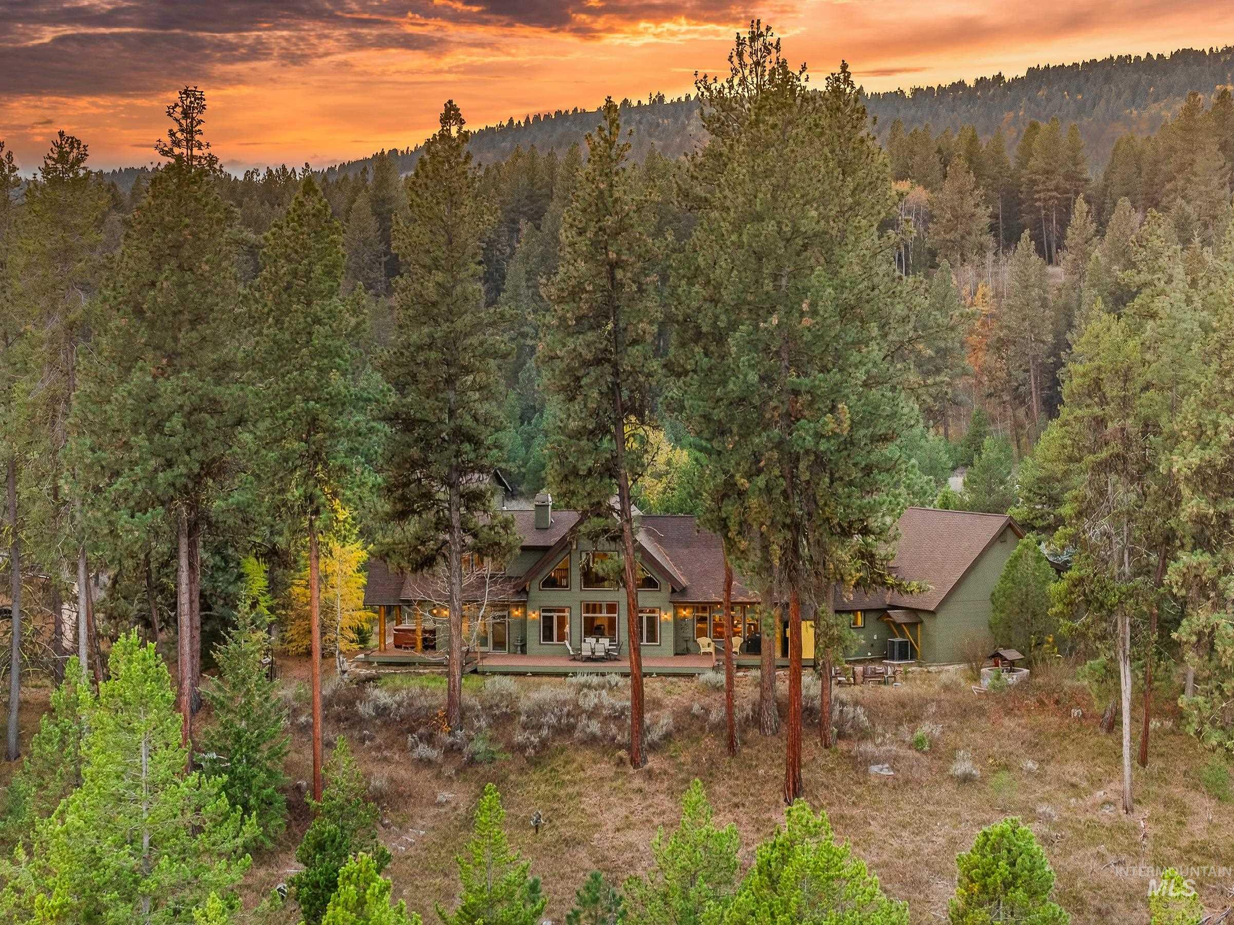 8 Bitterroot Court McCall, ID 83638 - Photo 50 of 50 Back of property at dusk featuring a wooded view and a porch