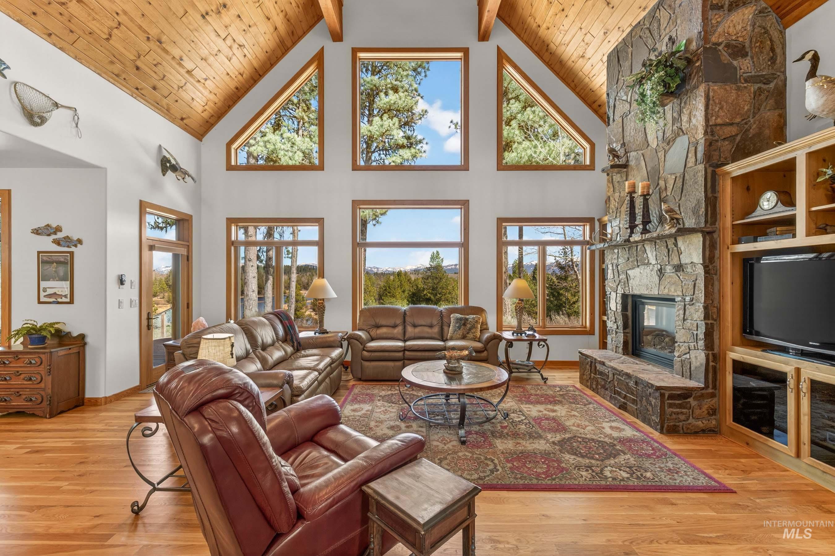 8 Bitterroot Court McCall, ID 83638 - Photo 5 of 50 Living room with light wood-style floors, a fireplace, plenty of natural light, and a high wooden beamed ceiling