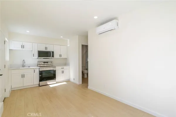 a large white kitchen with white cabinets and stainless steel appliances