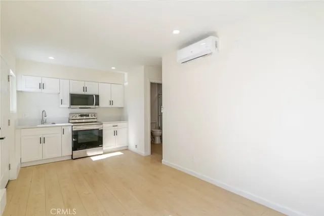 a large white kitchen with white cabinets and stainless steel appliances