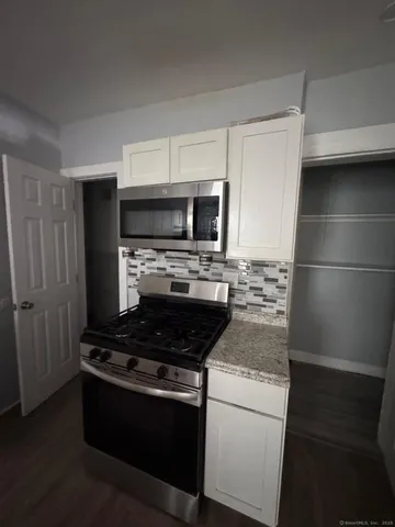 a kitchen with granite countertop a stove and a refrigerator