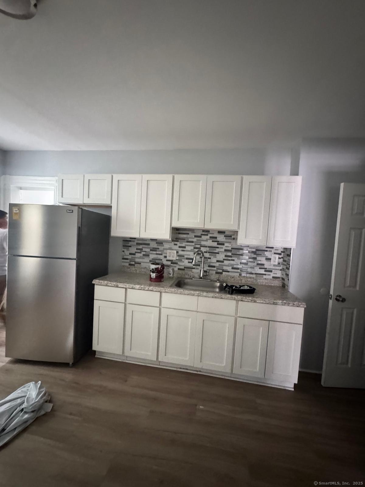 103 Caroline Street, Unit 1 Bridgeport, CT 06608 - Photo 2 of 9 a kitchen with stainless steel appliances granite countertop a refrigerator sink and white cabinets
