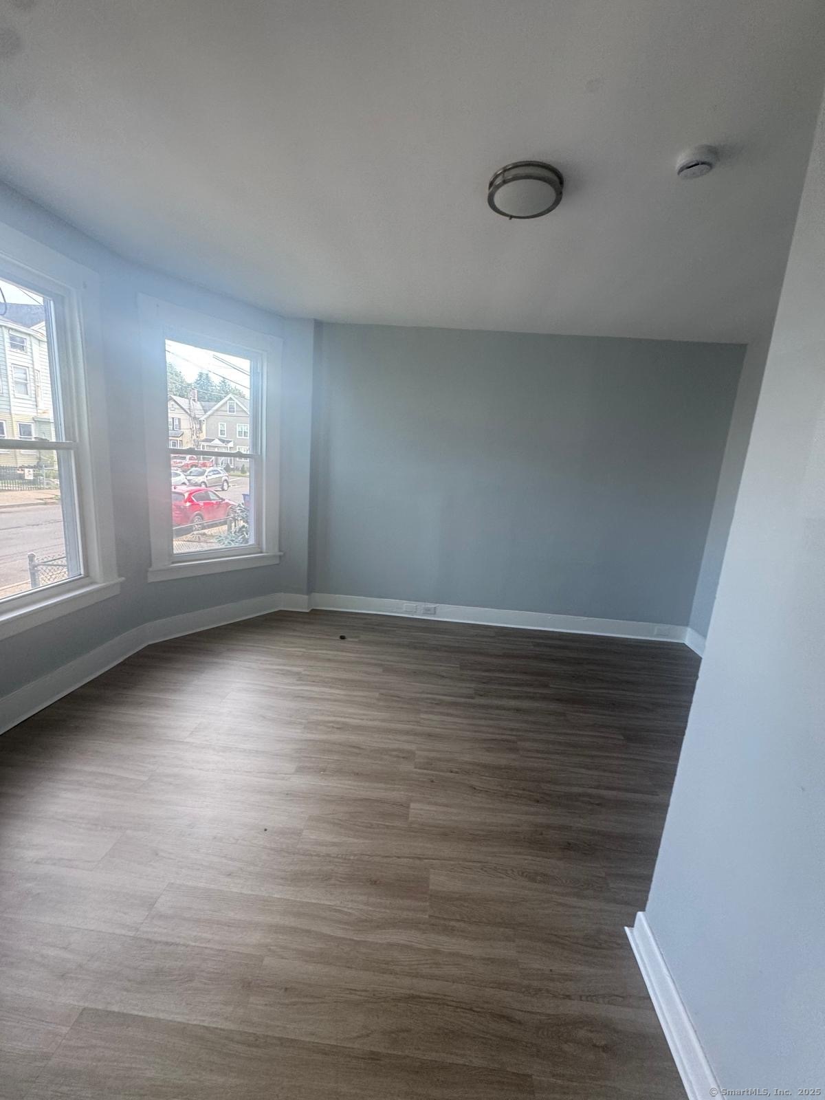 103 Caroline Street, Unit 1 Bridgeport, CT 06608 - Photo 5 of 9 an empty room with wooden floor and windows