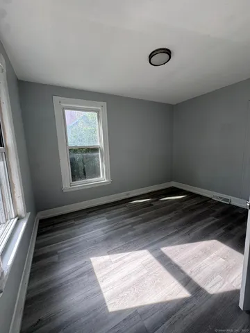 a view of a room with wooden floor and window