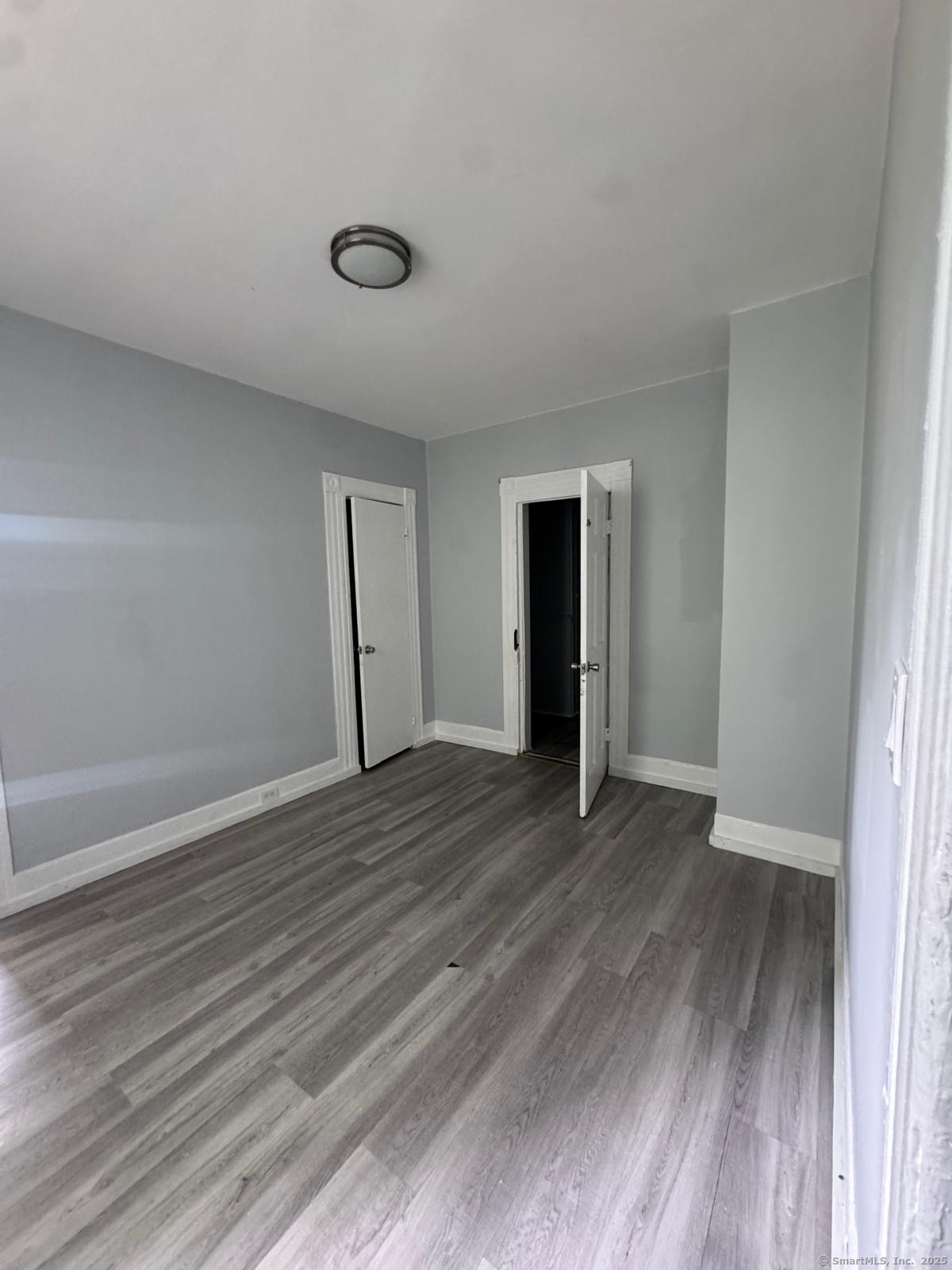 103 Caroline Street, Unit 1 Bridgeport, CT 06608 - Photo 9 of 9 a view of an empty room with wooden floor and a window
