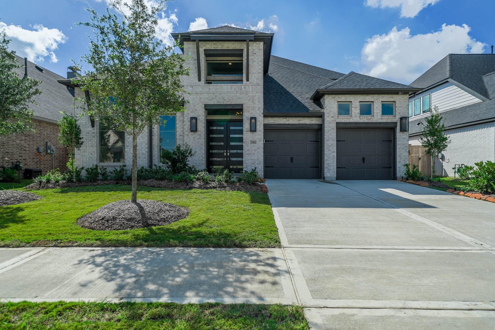 a front view of a house with a yard and trees