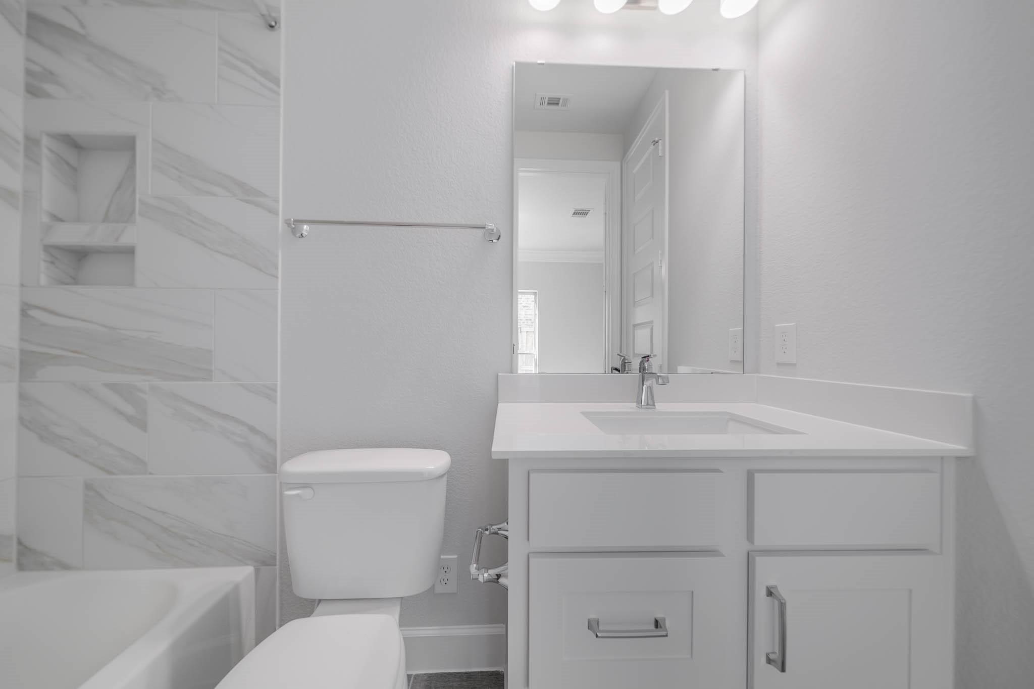 29103 Hauter Way Fulshear, TX 77441 - Photo 11 of 40 a bathroom with a sink toilet vanity and tub