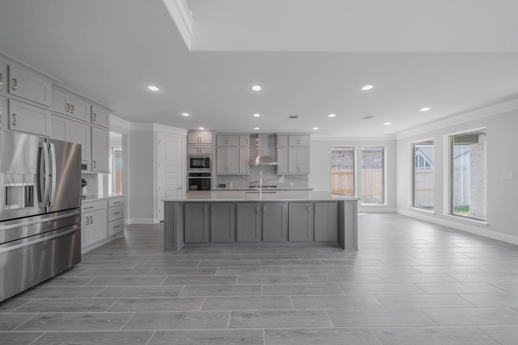 29103 Hauter Way Fulshear, TX 77441 - Photo 19 of 40 a large kitchen with kitchen island a sink stainless steel appliances and cabinets