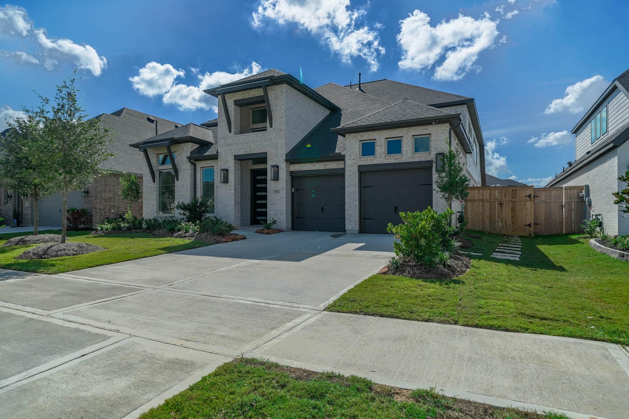 29103 Hauter Way Fulshear, TX 77441 - Photo 2 of 40 a front view of a house with a yard and a garden