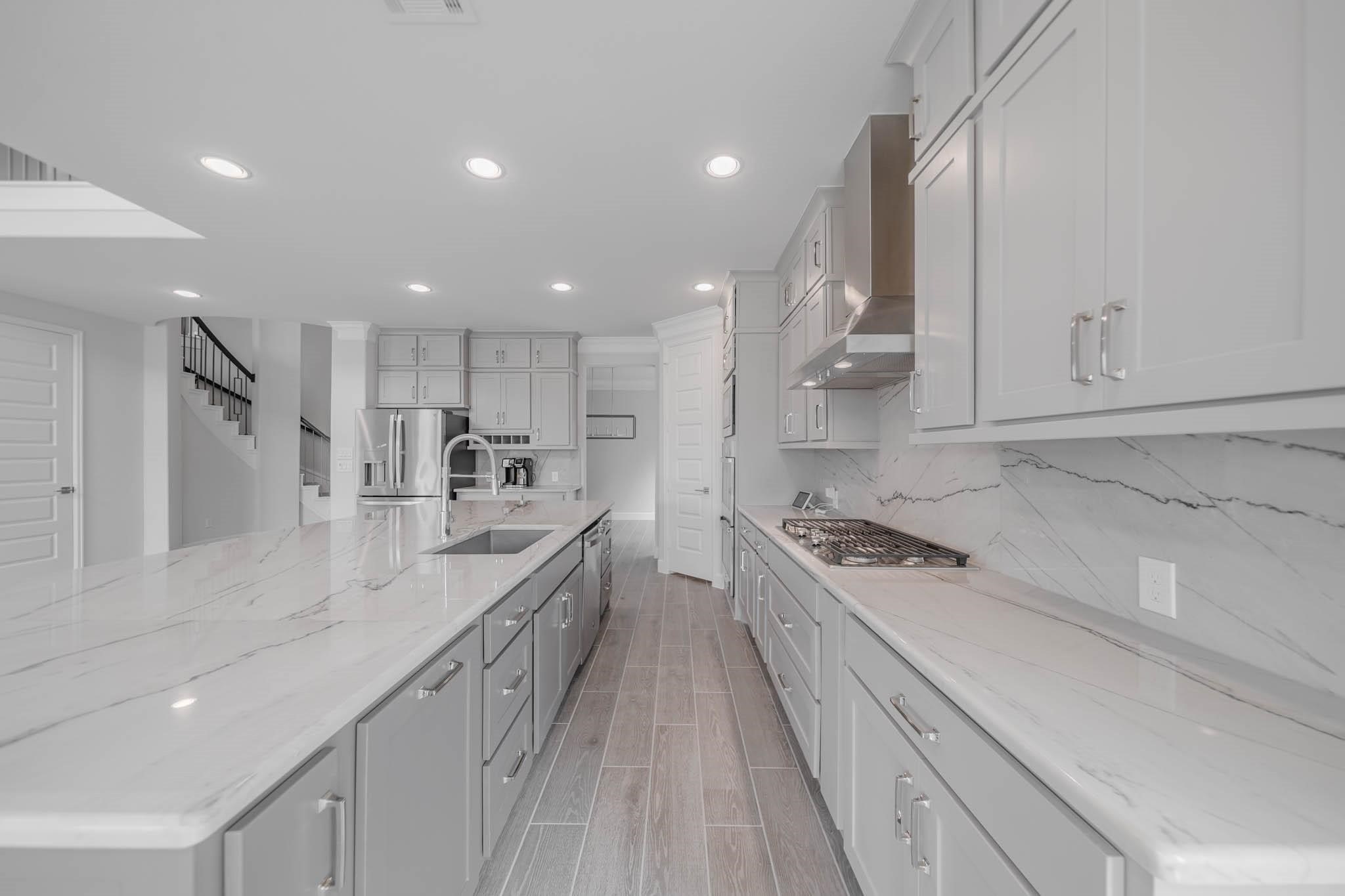 29103 Hauter Way Fulshear, TX 77441 - Photo 21 of 40 a kitchen with kitchen island white cabinets stainless steel appliances and a sink