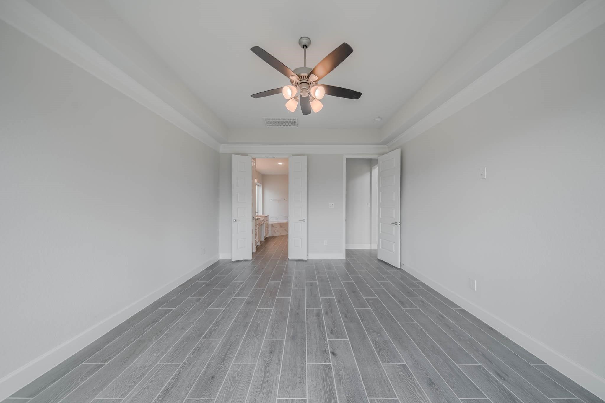 29103 Hauter Way Fulshear, TX 77441 - Photo 25 of 40 a view of wooden floor and chandelier fan in a room