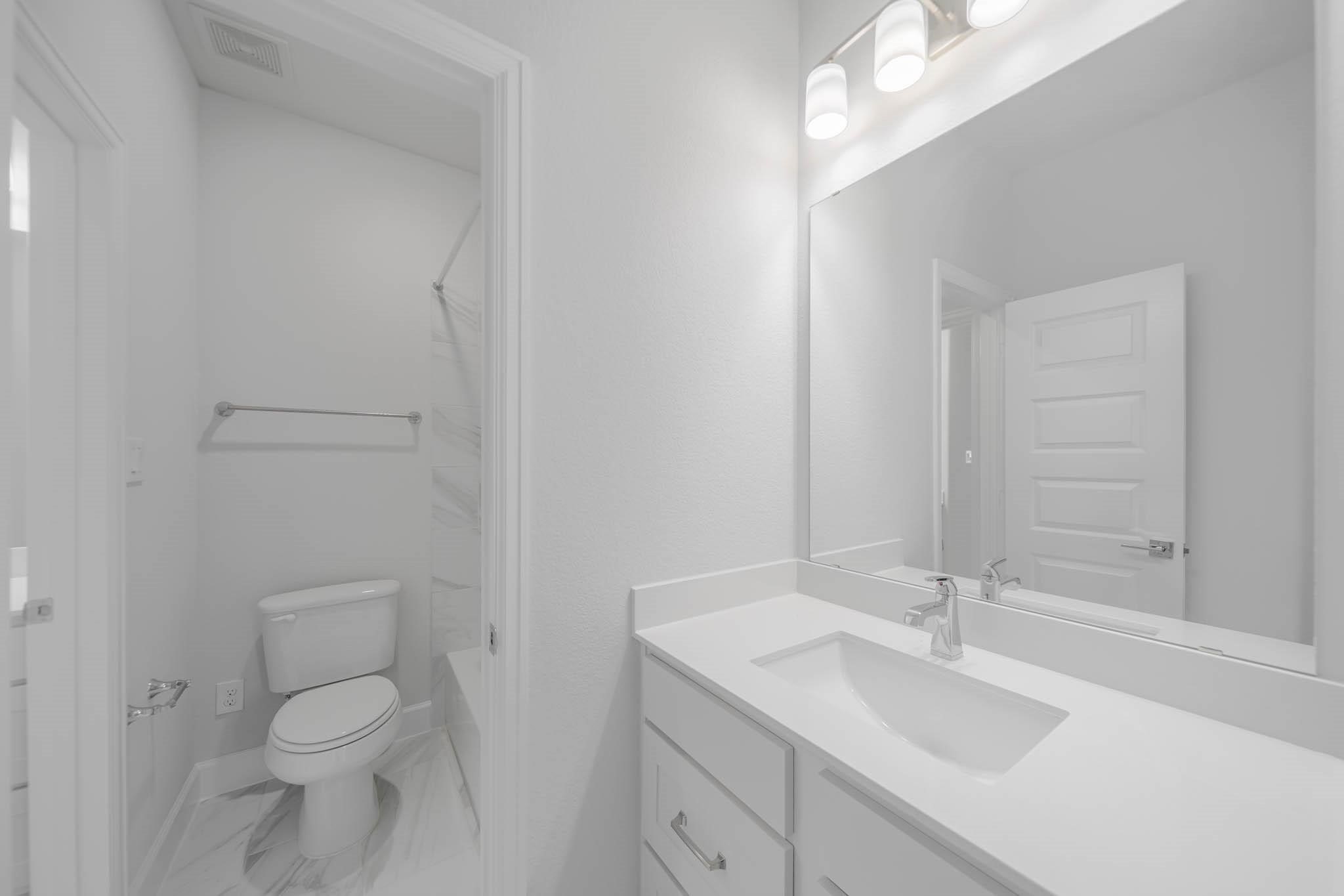 29103 Hauter Way Fulshear, TX 77441 - Photo 34 of 40 a bathroom with a toilet a sink and mirror