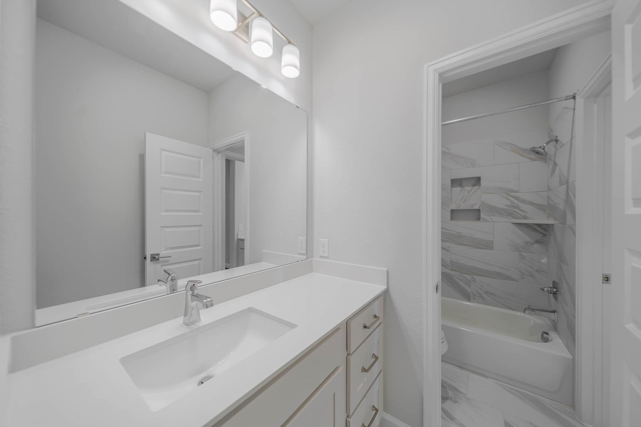 29103 Hauter Way Fulshear, TX 77441 - Photo 35 of 40 a bathroom with a bathtub sink vanity and mirror