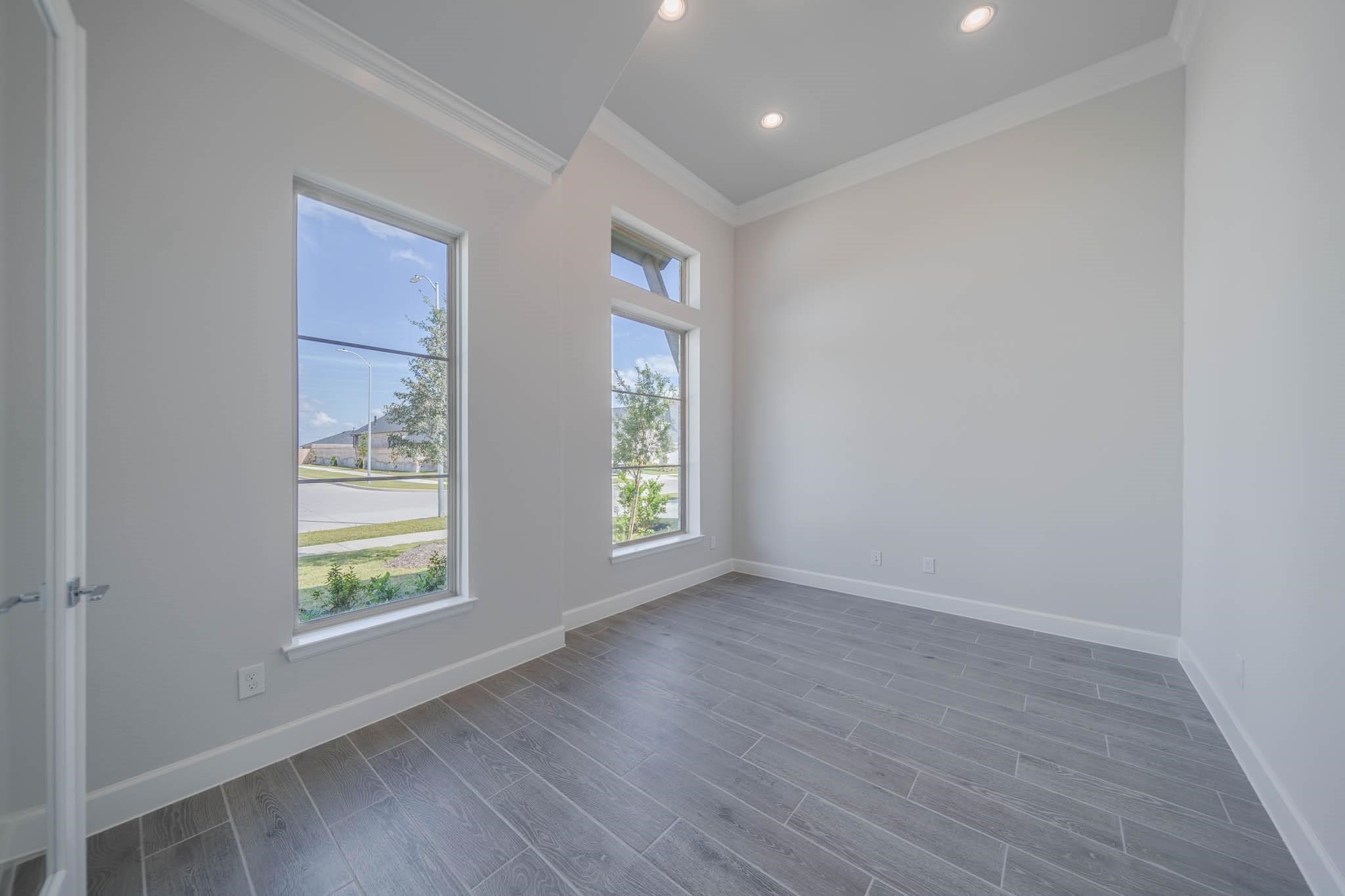 29103 Hauter Way Fulshear, TX 77441 - Photo 9 of 40 an empty room with wooden floor and windows
