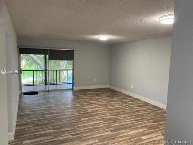 842 Southwest 9th St Circle, Unit 202 Boca Raton, FL 33486 - Photo 1 of 27 a view of an empty room with wooden floor and a window