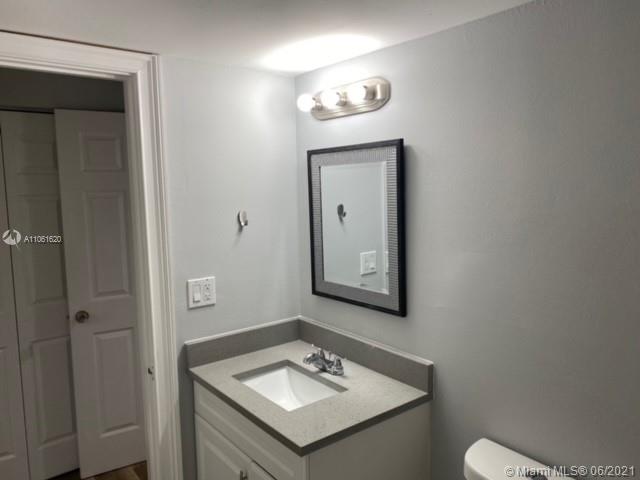 842 Southwest 9th St Circle, Unit 202 Boca Raton, FL 33486 - Photo 14 of 27 a bathroom with a sink vanity and a mirror