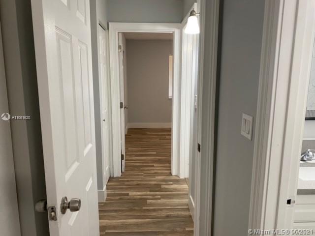 842 Southwest 9th St Circle, Unit 202 Boca Raton, FL 33486 - Photo 9 of 27 a view of a hallway with wooden floor and closet area