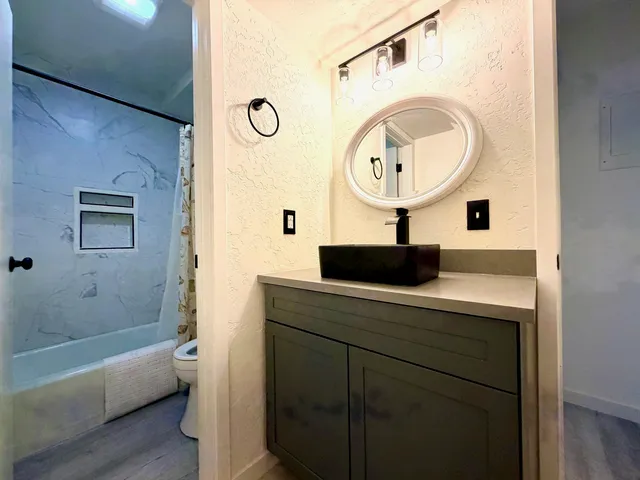 a bathroom with a sink a bathtub and a mirror