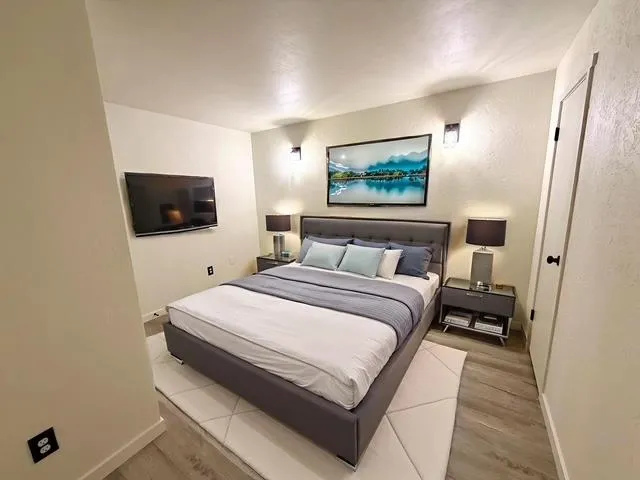 a bedroom with a bed and a flat screen tv