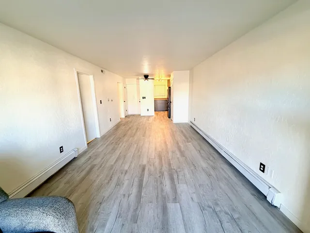 a view of empty room with wooden floor