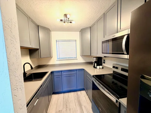 a kitchen with stainless steel appliances a sink stove and microwave