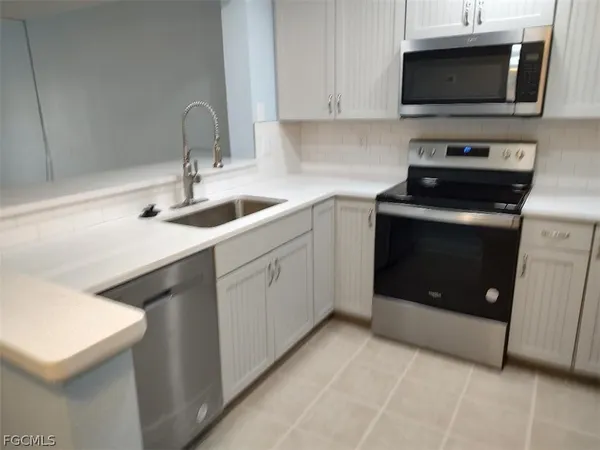 a kitchen with stainless steel appliances a stove microwave and sink