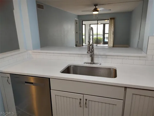 a close view of a sink and dishwasher with wooden floor