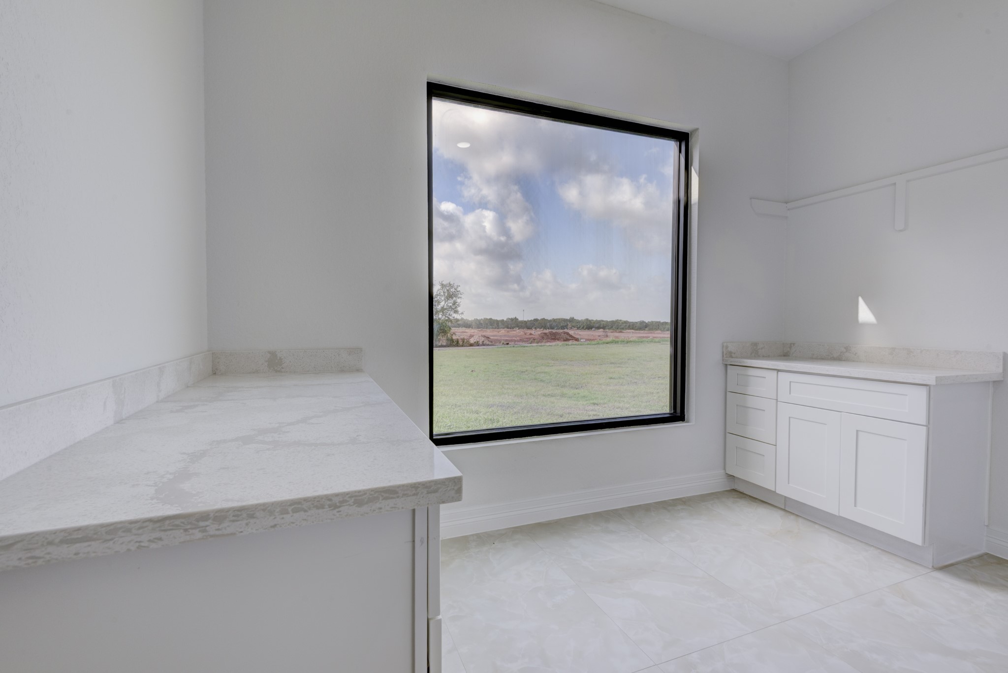 7348 Love Road Fulshear, TX 77441 - Photo 17 of 48 Bright and spacious laundry room with sleek countertops and a large window offering serene views of the outdoors.