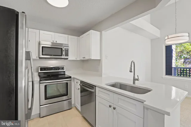 a kitchen with sink a microwave a stove and cabinets