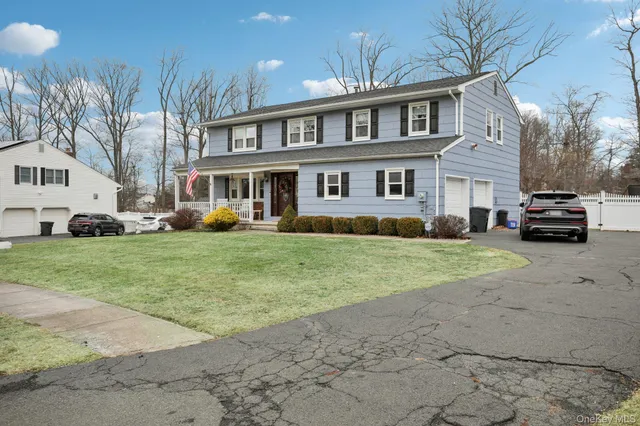 a front view of a house with a yard and trees