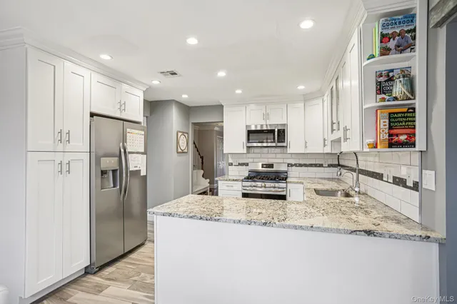 a kitchen with stainless steel appliances granite countertop a refrigerator and a stove top oven