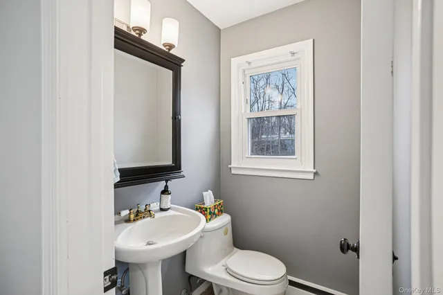a bathroom with a toilet a sink and mirror