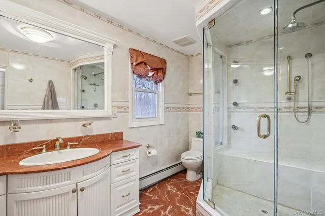 a bathroom with a sink toilet double vanity and shower