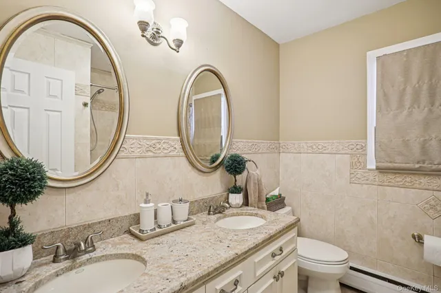 a bathroom with a granite countertop toilet a sink and a mirror