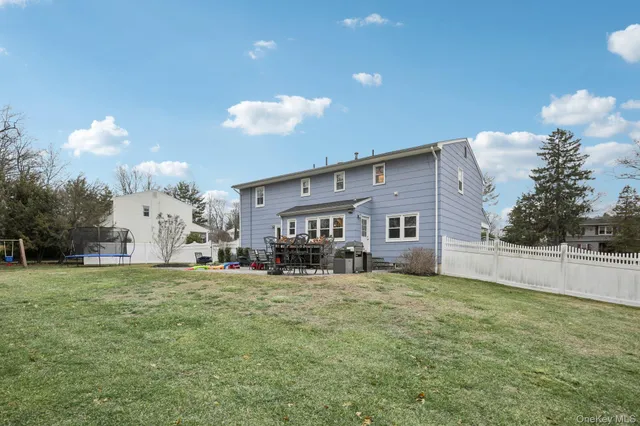 a view of a house with a big yard and a large tree
