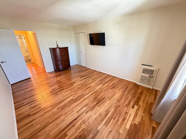 a view of a livingroom with wooden floor and a flat screen tv