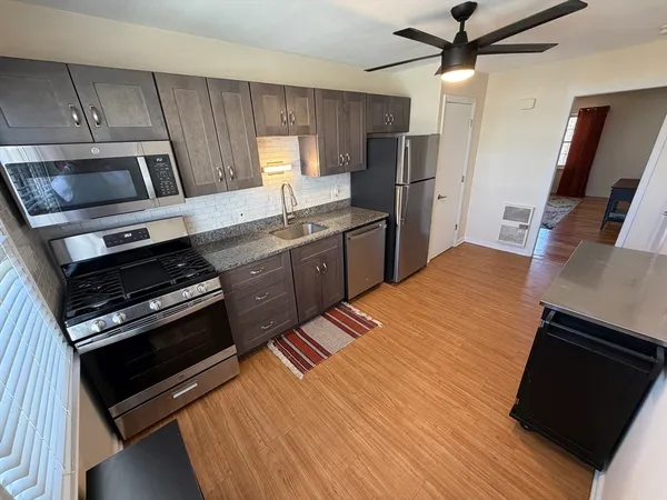 a kitchen with stainless steel appliances a stove a sink and a refrigerator