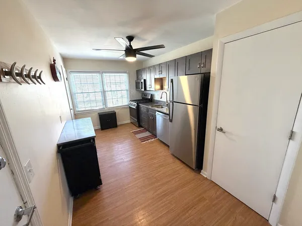 a kitchen with a refrigerator a sink and wooden floor